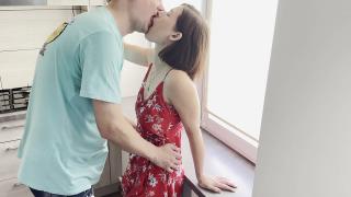 A couple in love is having sex in the kitchen near the window.
