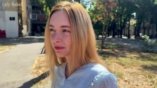 A blonde is filmed walking around the city.