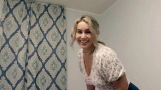 A smiling blonde is about to brush her teeth.